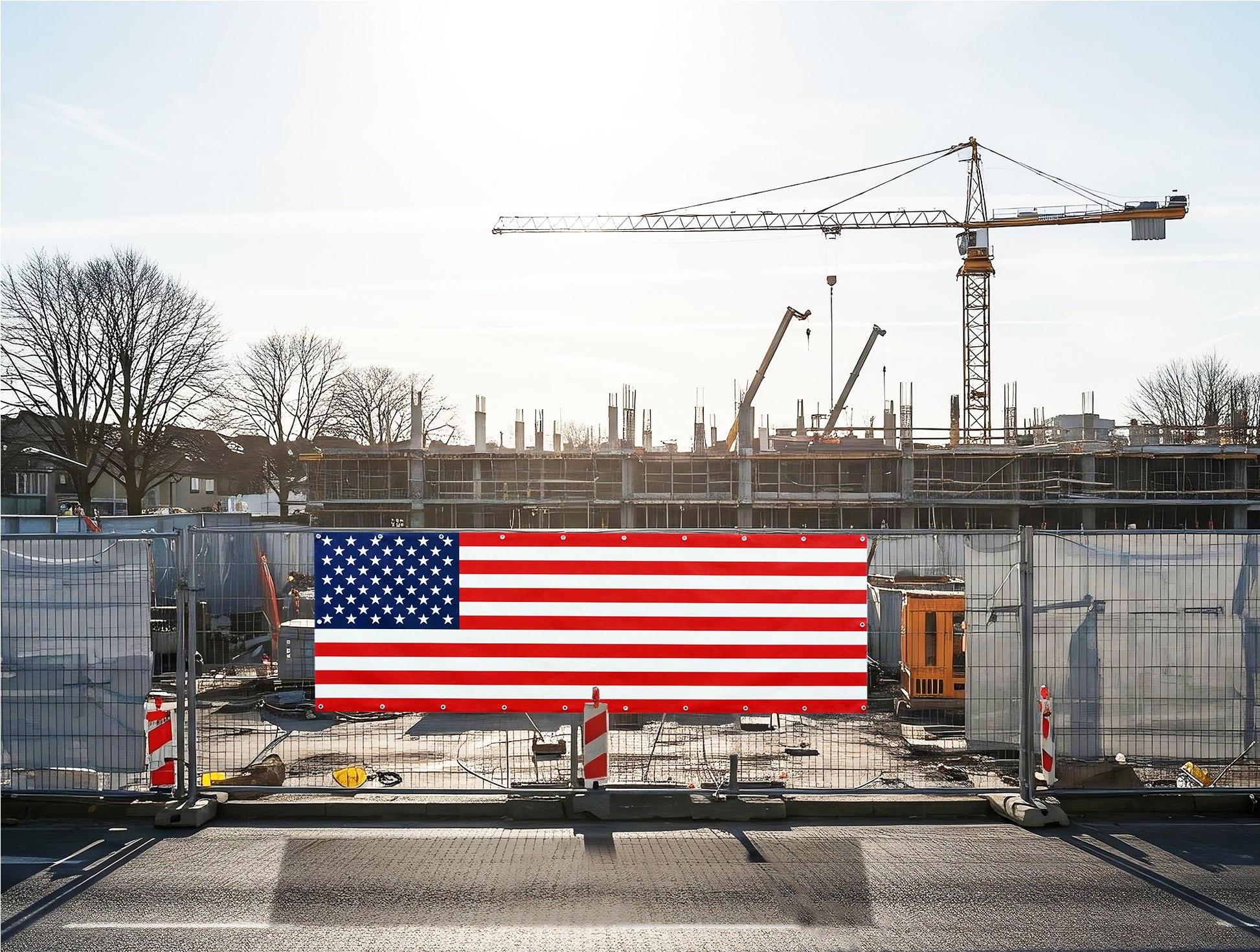 proud American flag vinyl banner on a construction site with cranes and buildings in the background