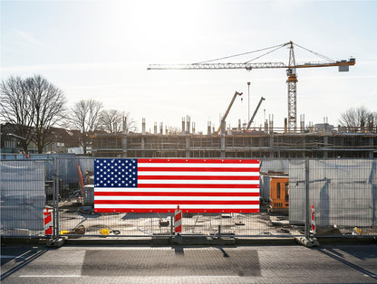 proud American flag vinyl banner on a construction site with cranes and buildings in the background